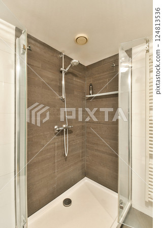 Sleek and contemporary shower cabin featuring glass walls and elegant wooden accents, ideal for modern bathroom aesthetics. Sleek and contemporary shower cabin featuring glass walls and elegant wooden accents, ideal for modern bathroom aesthetics. 124813536