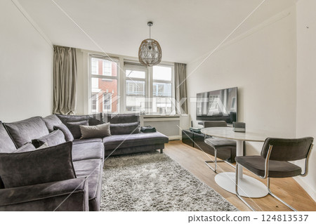 A contemporary living room showcasing elegant furniture, warm lighting, and a cozy atmosphere perfect for relaxation and socializing. 124813537