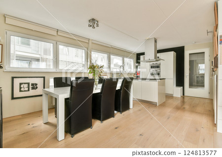 Contemporary kitchen design featuring large windows, sleek furniture, and a functional layout, creating a bright and inviting atmosphere for cooking and dining. Contemporary kitchen design featuring large windows, sleek furniture, and a functional layout, creating a bright and inviting atmosphere for cooking and dining. 124813577