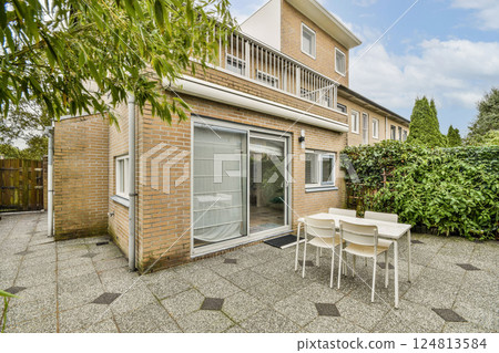 A contemporary home featuring a spacious outdoor area with a patio set amidst lush greenery and a clear sky, ideal for relaxation and entertainment. A contemporary home featuring a spacious outdoor area with a patio set amidst lush greenery and a clear sky, ideal for relaxation and entertainment. 124813584