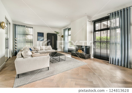 A stylish modern living room showcasing sleek furniture, abundant natural light, and elegant decor, creating a cozy yet sophisticated atmosphere. 124813628