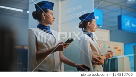 Two Beautiful Flight Attendants Talking, Waiting for Commercial Flight 124813706