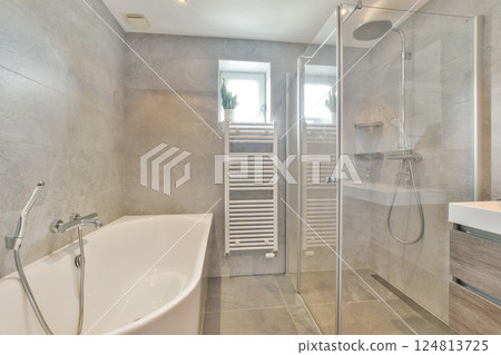 A sleek modern bathroom featuring a glass shower enclosure, a freestanding bathtub, and sophisticated tile work that exudes elegance and comfort. A sleek modern bathroom featuring a glass shower enclosure, a freestanding bathtub, and sophisticated tile work that exudes elegance and comfort. 124813725