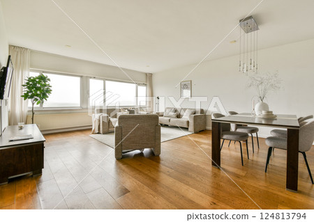 A spacious and modern living room featuring contemporary furniture, large windows allowing natural light, and a minimalist aesthetic. Ideal for relaxation and gatherings. A spacious and modern living room featuring contemporary furniture, large windows allowing natural light, and a minimalist aesthetic. Ideal for relaxation and gatherings. 124813794