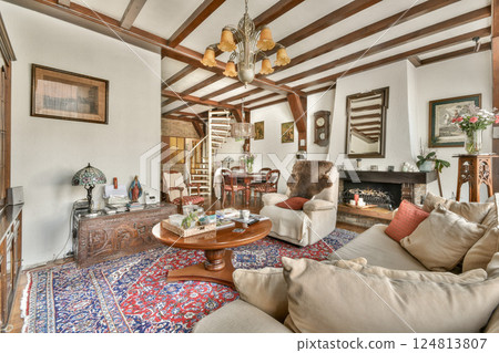 A warm and inviting rustic living room featuring wooden beams, elegant decor, and comfortable seating. Ideal for relaxation and gatherings. A warm and inviting rustic living room featuring wooden beams, elegant decor, and comfortable seating. Ideal for relaxation and gatherings. 124813807