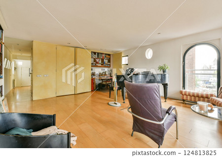 An elegant modern interior featuring a piano, wooden flooring, and a well-lit space accentuated by innovative design elements. 124813825
