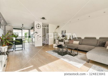 A spacious, contemporary living room featuring sleek furniture, large windows, and greenery, showcasing a blend of comfort and elegance in design. A spacious, contemporary living room featuring sleek furniture, large windows, and greenery, showcasing a blend of comfort and elegance in design. 124813841