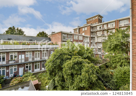 A view showcasing a modern urban residential complex with lush greenery and gardens. The architecture highlights a blend of nature and urban living. 124813845