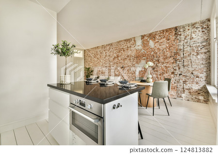 A sleek modern kitchen featuring a white design with brick accents, seamlessly blending functionality and style in an inviting space. 124813882