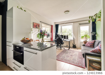 A bright and inviting interior showcasing modern furniture, greenery, and stylish decor, creating a warm atmosphere perfect for relaxation. 124813966