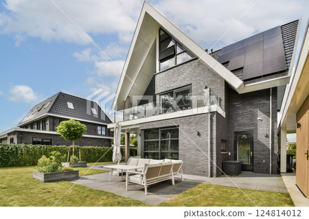This contemporary home features sleek architecture, solar panels, and a beautifully landscaped garden, showcasing sustainable living in a serene environment. 124814012
