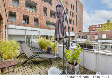 A stylish urban terrace featuring contemporary architecture, lounge chair, and lush greenery, perfect for relaxation and outdoor gatherings. A stylish urban terrace featuring contemporary architecture, lounge chair, and lush greenery, perfect for relaxation and outdoor gatherings. 124814021
