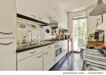 A stylish modern kitchen featuring sleek cabinetry, stainless appliances, and abundant natural light streaming through large windows. A stylish modern kitchen featuring sleek cabinetry, stainless appliances, and abundant natural light streaming through large windows. 124814067