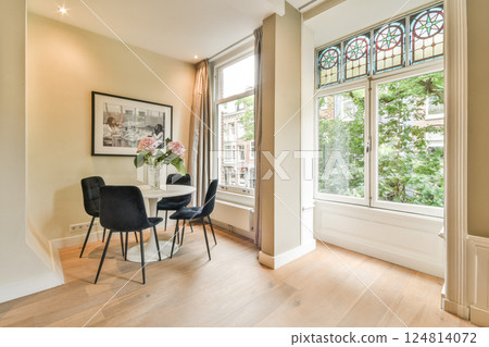 An elegantly designed room featuring minimalist furniture and natural light streaming through large windows, creating a serene atmosphere. 124814072