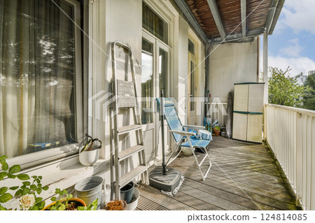 A well-furnished balcony featuring a comfortable chair, potted plants, and a scenic view. Perfect for relaxation and enjoying outdoor moments. 124814085