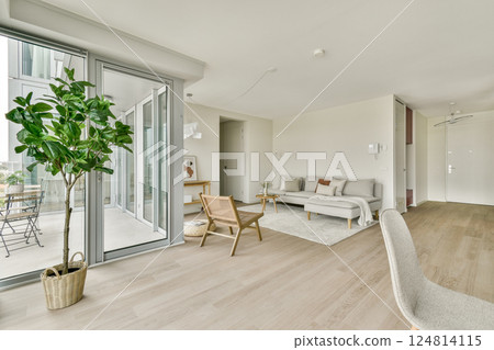 A stylish, modern living room featuring minimalistic furniture, large windows, and a touch of greenery, creating a serene and inviting atmosphere. 124814115