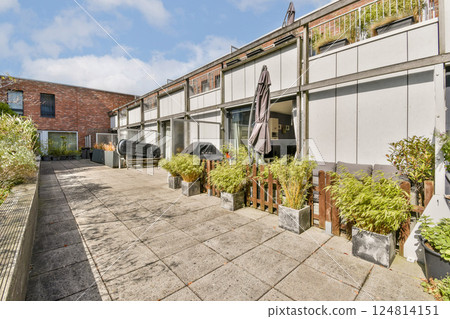 A beautifully designed outdoor residential area featuring contemporary architecture, lush greenery, and a peaceful atmosphere perfect for relaxation. 124814151