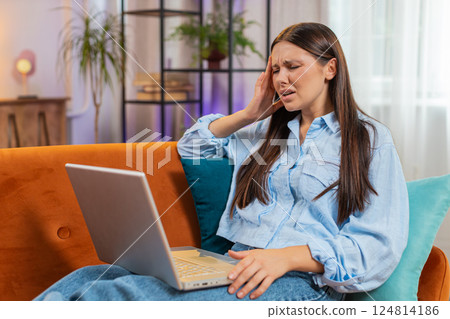 Tired young woman using laptop suffering from headache problem tension and migraine stress at home Tired young woman using laptop suffering from headache problem tension and migraine stress at home 124814186