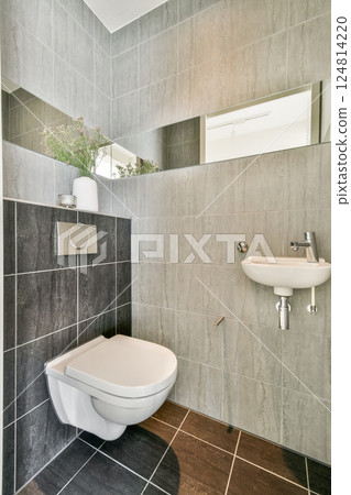 A sleek and contemporary bathroom featuring gray tiles, elegant fixtures, and minimalistic decor, showcasing a fresh and clean aesthetic. 124814220