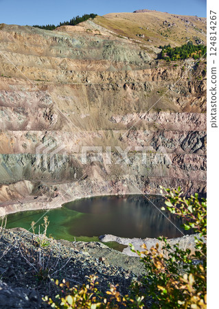 Old open mining pit with pond in mountain 124814267