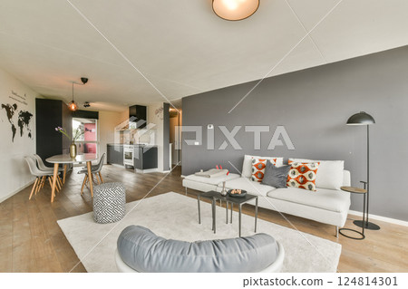 A stylish, modern living room featuring a minimalist design with elegant furniture, warm lighting, and a touch of global decor. Perfect for contemporary home aesthetics. 124814301