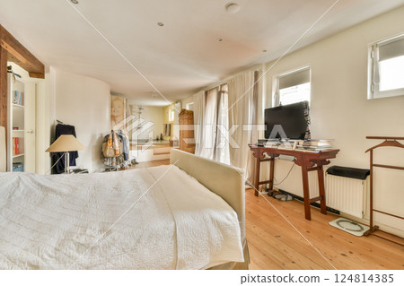 Breezy interior space featuring a neatly made bed, soft furnishings, and ample natural light streaming through windows, creating a serene atmosphere. Breezy interior space featuring a neatly made bed, soft furnishings, and ample natural light streaming through windows, creating a serene atmosphere. 124814385