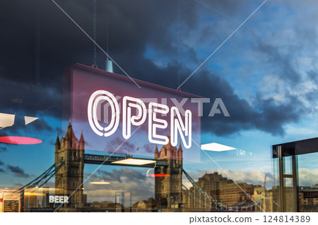Illuminated OPEN sign with Tower Bridge view through glass window Illuminated OPEN sign with Tower Bridge view through glass window 124814389