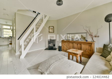 A stylish living room featuring a cozy sofa, elegant wooden furniture, and a blend of natural light that enhances the minimalist decor. A stylish living room featuring a cozy sofa, elegant wooden furniture, and a blend of natural light that enhances the minimalist decor. 124814462