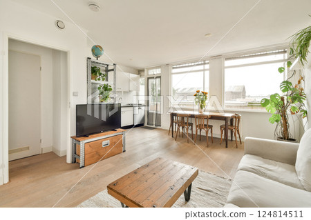 A chic living room showcasing a bright and airy design with large windows, minimal furniture, and natural elements enhancing the modern aesthetic. A chic living room showcasing a bright and airy design with large windows, minimal furniture, and natural elements enhancing the modern aesthetic. 124814511