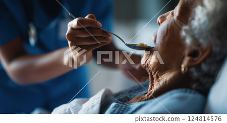 healthcare professional in blue uniform feeding elderly patient with care and compassion healthcare professional in blue uniform feeding elderly patient with care and compassion 124814576