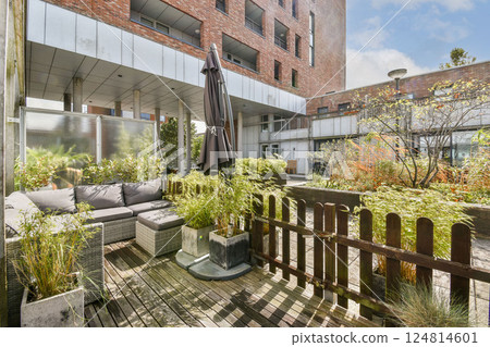 A contemporary outdoor seating area featuring stylish furniture and vibrant plants, creating a cozy and inviting atmosphere for relaxation. 124814601