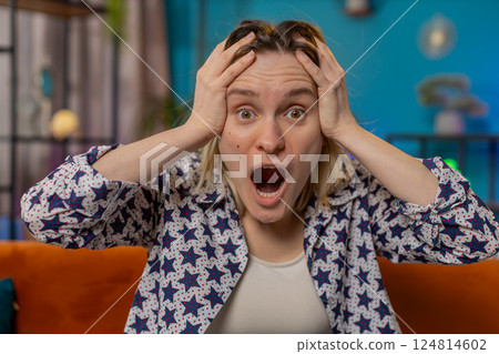 Excited amazed young woman surprised looking at camera good win news wow emotion celebrating success 124814602