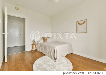 A serene and stylish minimalist bedroom featuring light colors, wooden flooring, and simple decor, creating a calm and inviting atmosphere. A serene and stylish minimalist bedroom featuring light colors, wooden flooring, and simple decor, creating a calm and inviting atmosphere. 124814641