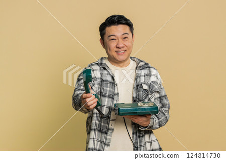 Asian man talking on wired landline vintage telephone, advertising proposition of conversation 124814730