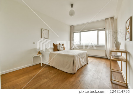 A serene and modern bedroom design showcasing a minimalist aesthetic with a light color palette and stylish furnishings. 124814795