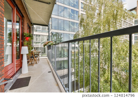 A beautifully designed balcony showcasing a blend of modern architecture and natural elements, featuring greenery and stylish outdoor furniture. 124814796