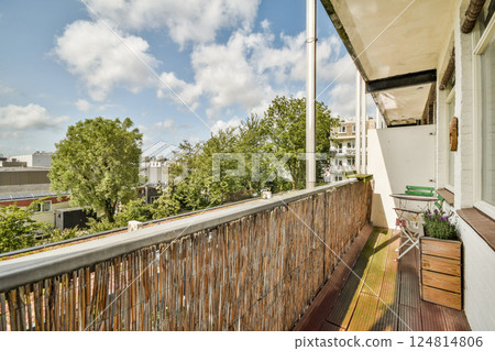A bright balcony showcasing vibrant greenery, a peaceful ambiance, and a glimpse of the clouds above, inviting relaxation and enjoyment of nature. A bright balcony showcasing vibrant greenery, a peaceful ambiance, and a glimpse of the clouds above, inviting relaxation and enjoyment of nature. 124814806