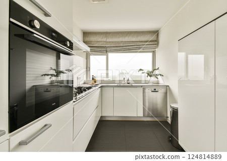 A sleek and contemporary kitchen space featuring a minimalist aesthetic with integrated appliances and a bright atmosphere. Ideal for modern living. 124814889