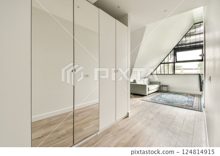 A stylish interior featuring sleek cabinets, elegant furniture, and a vibrant rug in a well-lit room with modern architectural elements. 124814915