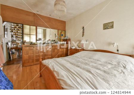 A warm and inviting bedroom featuring a wooden bed, subtle lighting, and tasteful decor, ideal for relaxation and comfort. A warm and inviting bedroom featuring a wooden bed, subtle lighting, and tasteful decor, ideal for relaxation and comfort. 124814944