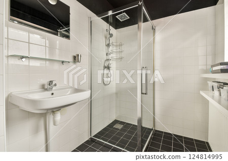 A contemporary shower room featuring a sleek glass enclosure and minimalistic design elements, perfect for a refreshing bathing experience. 124814995