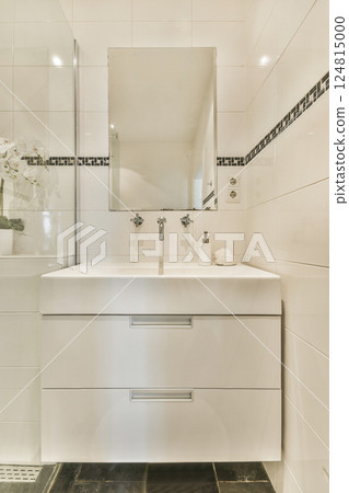 A sleek modern bathroom featuring a minimalist sink and an adjacent shower space, illuminated with natural light and decorated with elegant fixtures. A sleek modern bathroom featuring a minimalist sink and an adjacent shower space, illuminated with natural light and decorated with elegant fixtures. 124815000