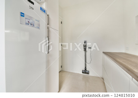 A sleek modern kitchen featuring a built-in refrigerator, minimalist design, and elegant countertops. The light tones enhance the spacious feel of the area. A sleek modern kitchen featuring a built-in refrigerator, minimalist design, and elegant countertops. The light tones enhance the spacious feel of the area. 124815010