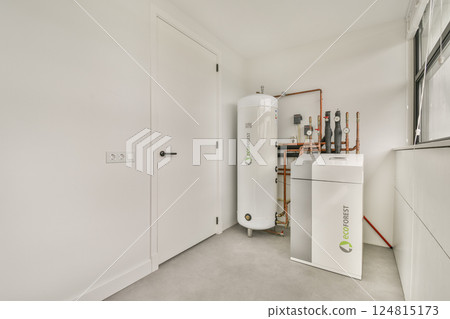 A sleek and contemporary utility room featuring modern equipment, including a white storage unit and compressed air tank against a minimalist backdrop. A sleek and contemporary utility room featuring modern equipment, including a white storage unit and compressed air tank against a minimalist backdrop. 124815173