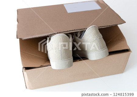 A pair of new beige sneakers in a box. 124815399