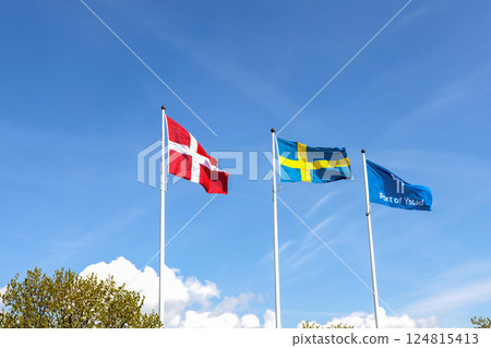 Denmark and Sweden flags and the flag of the port of the city of Ystad against blue sky Denmark and Sweden flags and the flag of the port of the city of Ystad against blue sky 124815413