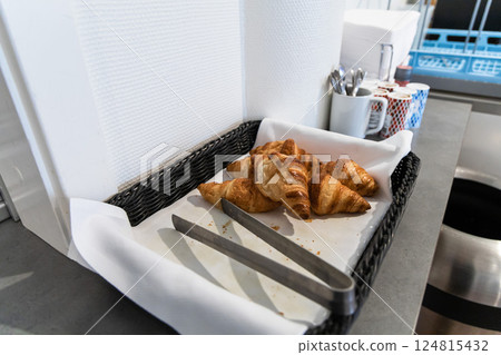 Fresh croissants in a bastet in a hotel kitchen. Fresh croissants in a bastet in a hotel kitchen. 124815432