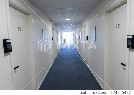 Long white corridor with a window at the end in a hotel. 124815437