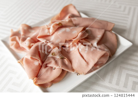 Thinly sliced sausage, ham on a white plate 124815444