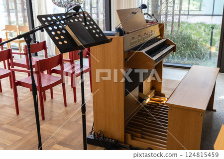 Small indoors pipe organ. Musical instrument for church singing. 124815459
